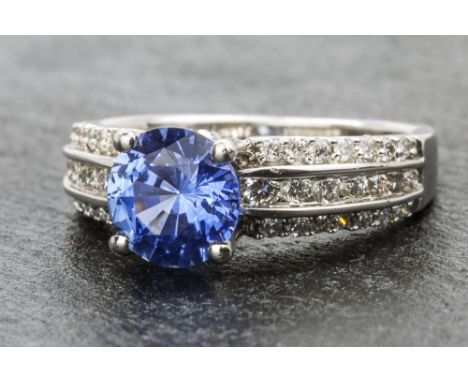 An 18ct white gold, Ceylon sapphire and diamond ring the round cut 1.83 carat Ceylon sapphire flanked by tiered shoulders set