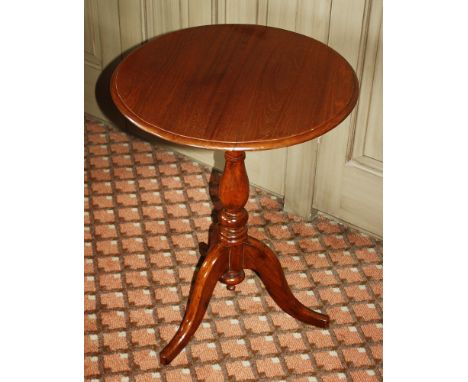 A Victorian mahogany tilt-top tripod table the circular top on a baluster turned column to three swept supports, 20in. (51cm.