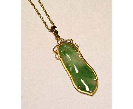 An 18ct gold and jade pendant late 20th century, the jade in the form of a beansprout, within a yellow gold border on a fine 