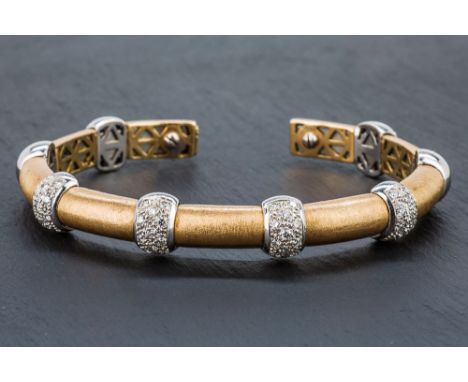 An 18ct burnished yellow gold, white gold and diamond flexible bangle the burnished D-section bangle set with eight convex wh