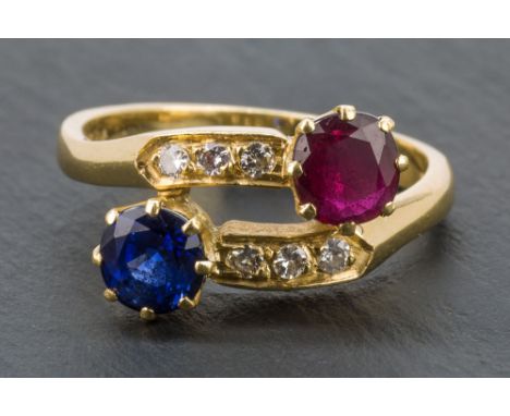 An 18ct yellow gold, sapphire, ruby and diamond cross over ring F. E. Ullmann, London 1986, ring size M.