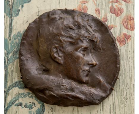 A cast bronze portrait plaque probably first half 20th century, depicting a young man in profile, 7in. (17.5cm.) diameter.