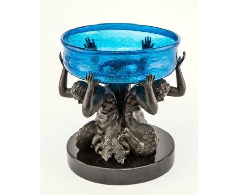 A 19th century and later bronze and glass standish the bronze stand with three mermen, holding aloft a blue soda glass dish, 