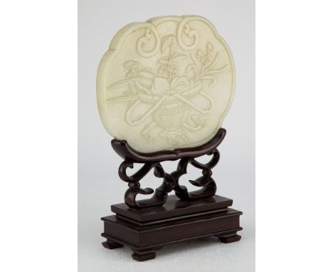 A Chinese pale celadon jade plaque probably 19th century, originally a box cover, of lobed form, with well carved decoration 