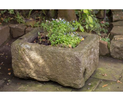 A small antique granite trough 26 x 21in. (66 x 53.25cm.), 14¼in. (36.25cm.) high, the sides 4in. (10cm.) thick.