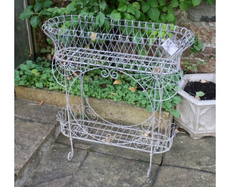 A Victorian style wirework planter of rounded rectangular form, the narrow basket top on four scroll-footed supports above a 