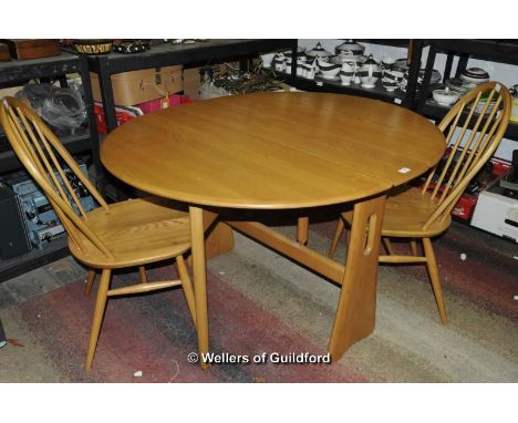 An Ercol oval dropleaf dining table, 106 x 121cm extended; two Ercol stickback dining chairs.