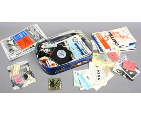 A tin of mixed ephemera and collectables including vintage football programmes, pin badges, photographs, railway ticket stubs