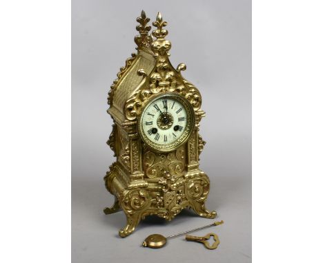 A French brass cased eight day mantel clock of architectural form. With enamel chapter ring and striking half hourly on a bel