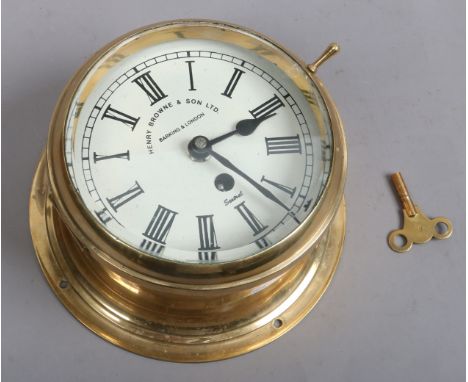 A brass eight day bulk head ships dock with printed enamel dial, signed Henry Brow & Son Limited Barking & London with key.