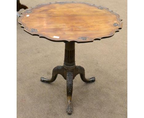 ^ A George III carved mahogany tripod table, late 18th century, the circular dish top raised on a vasiform support with three