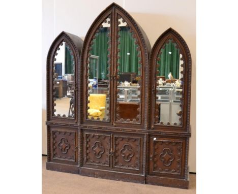 A Gothic revival pine wardrobe, late 19th/early 20th century, in three sections, central section with two mirror doors enclos