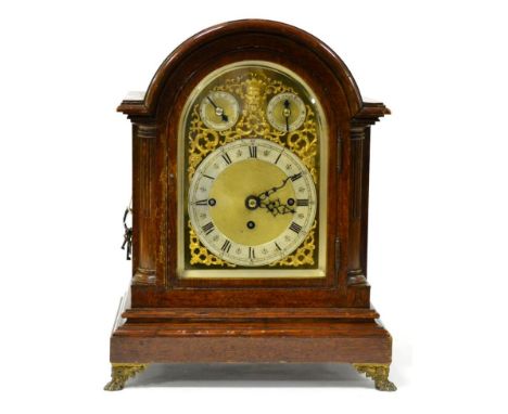 An oak chiming table clock, circa 1900, arched case, gilt metal pierced side frets, claw feet, arched brass dial, two dials f