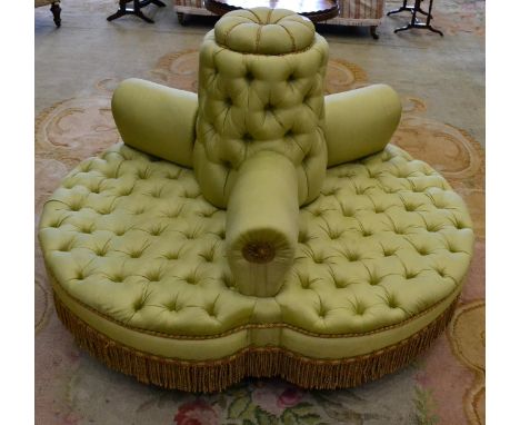 A Victorian style three-seater conversation settee, upholstered in button green watered silk with overstuffed back support, a