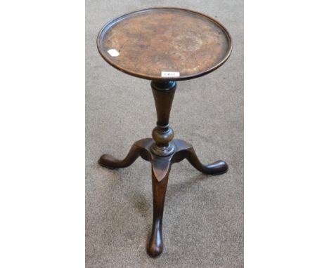 A burr walnut tripod stand in George II style, the circular dished top raised on a turned tapering support with three cabriol