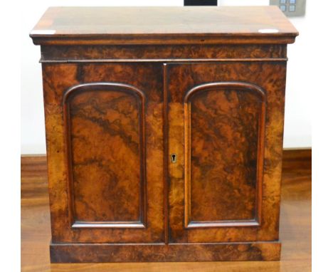 A Victorian figured walnut collectors cabinet, in the form of a miniature wardrobe, circa 1870, with two moulded cupboard doo