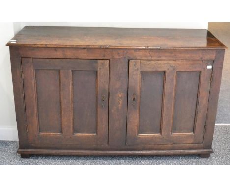 An 18th century joined oak two-door cupboard, with fielded panel doors and plinth base raised on block feet, 141cm wide