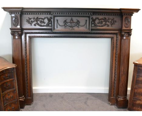 A late 19th century carved mahogany mantelpiece in Adam style, of breakfront form, the acorn and dentil cornice above a table