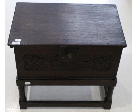 An oak bible box, late 17th/early 18th century, with hinged lid above a carved panel raised on a later stand with gun barrel 