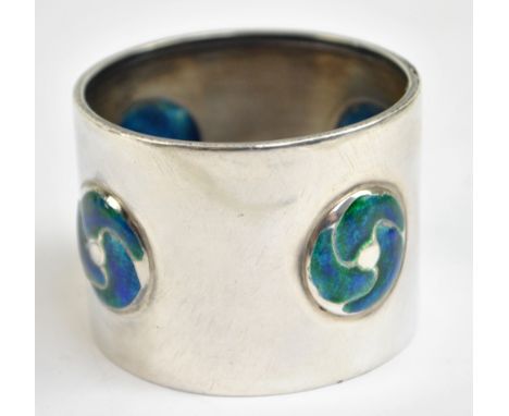 WILLIAM HAIR HASELER; an Edwardian Arts and Crafts hallmarked silver and enamel decorated napkin ring set with stylised round