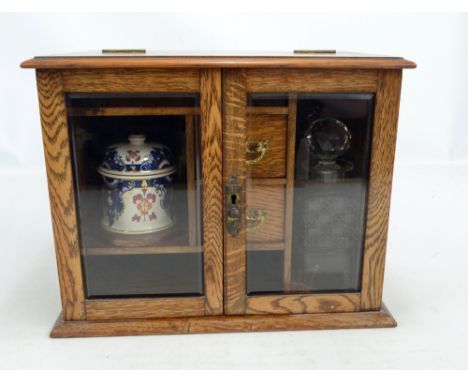 An oak tabletop cabinet housing two clear glass decanters, ceramic jar and two dishes, 30 x 38 x 24cm.