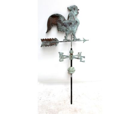 A weathervane surmounted by a large cock above an arrow.