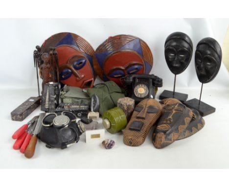 A group of modern tribal masks and figures with further items including two rubber masks, vintage telephone, etc. 
