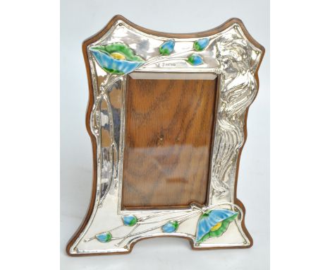 WILLIAMS (BIRMINGHAM) LTD; an Edward VII hallmarked silver fronted Art Nouveau shaped rectangular photo frame embossed with a