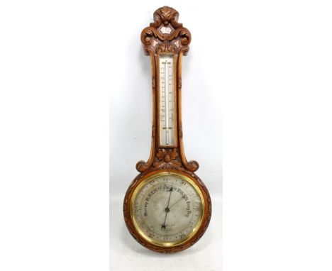 A late Victorian carved oak banjo barometer/thermometer, the silvered dial signed 'J Hicks, London 8814', height 71cm.