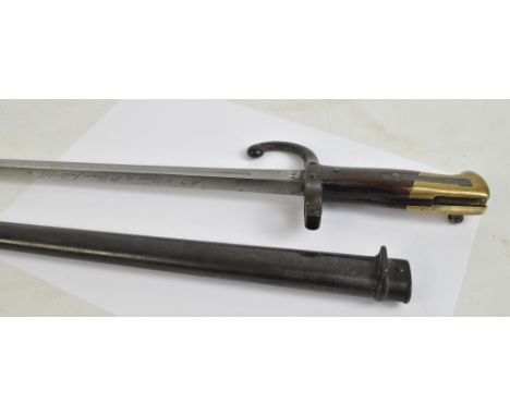 A 19th century French bayonet with wooden and brass handle, St Etienne 1879, length of blade 52cm, with metal scabbard.