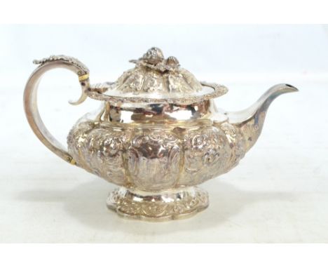 EDWARD BARTON; a George IV hallmarked silver circular teapot of squat lobed form overall embossed with floral and foliate mot