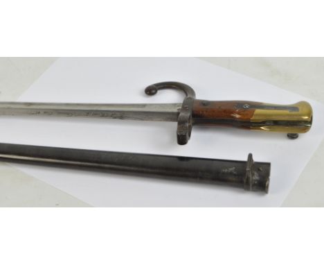 A 19th century French bayonet with wooden and brass handle, St Etienne 1886, length of blade 52cm, with metal scabbard.
