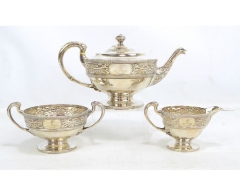 A George V Scottish hallmarked silver three piece tea set with band of stylised dragon and Celtic motifs, and engraved armori