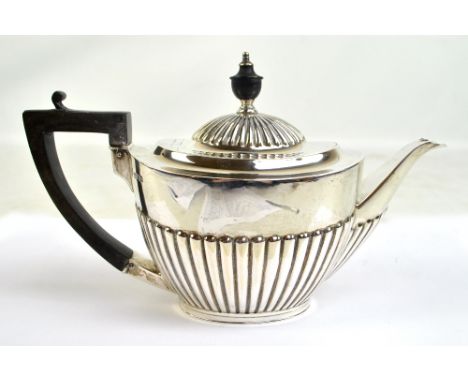 GOLDSMITHS & SILVERSMITHS LTD; a George V hallmarked silver part gadrooned teapot of oval form with flush hinged lid, length 