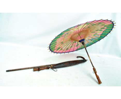 An early 20th century hallmarked silver mounted bamboo walking stick and two paper parasols (3).