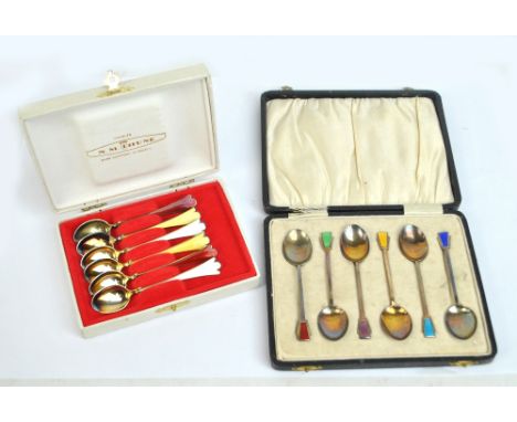 A cased pair of George V hallmarked silver and enamel decorated Art Deco coffee spoons, Birmingham 1932, and a cased set of s