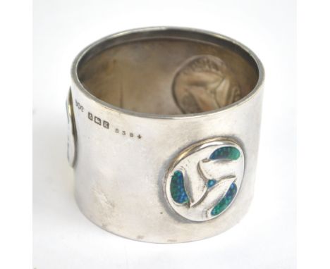 LIBERTY & CO; an Edward VII Arts and Crafts hallmarked silver and enamel decorated napkin ring set with three stylised rounde