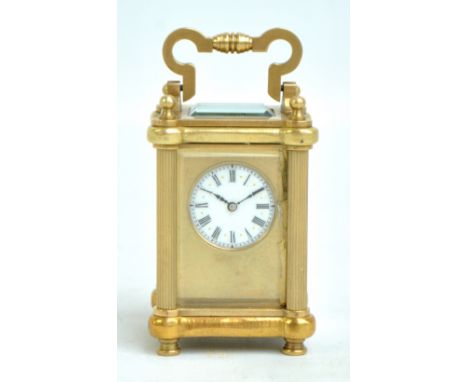 A French brass carriage clock of small proportions, the enamelled dial set with Roman numerals, unsigned, height excluding ha