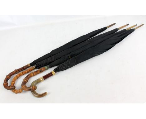 Four vintage umbrellas (4). CONDITION REPORT: Wear to metal bands and silk to all four umbrellas.