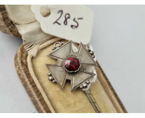 A boxed silver garnet cross stick pin