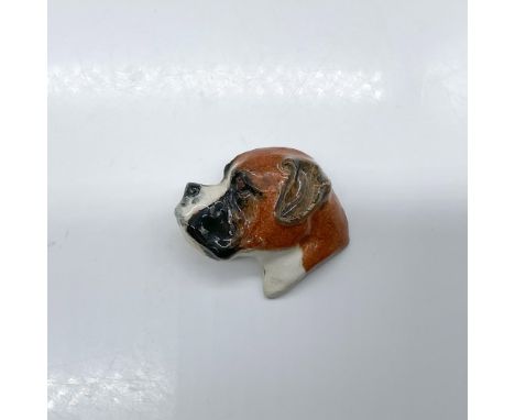 Pottery pin molded as a dog head; needle pin fasten. Brown, black, and white coloration. Royal Doulton impressed stamp. Issue