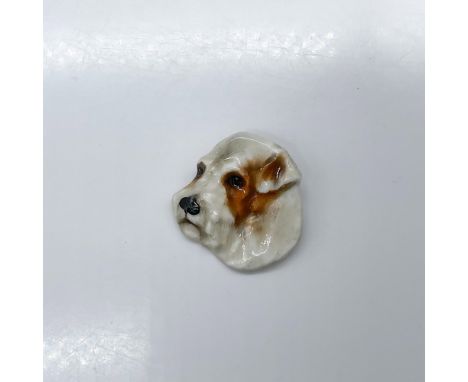 Pottery pin molded as a terrier head; needle pin fasten. White and brown coloration. Royal Doulton impressed stamp. Issued: 1