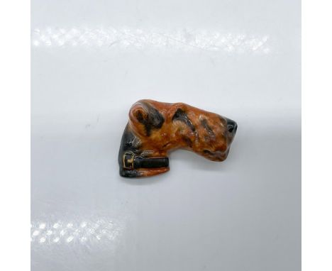 Pottery pin molded as a dog head; needle pin fasten. Black and dark brown coloration. Royal Doulton impressed stamp. Issued: 