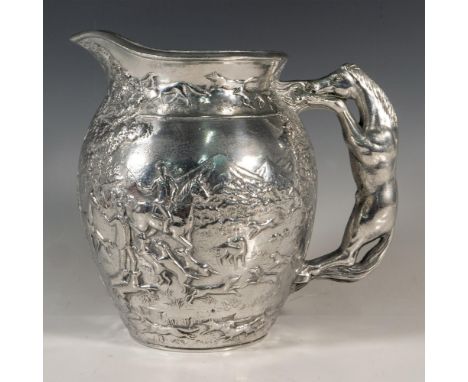 A stunning cast silvery metalwork jug featuring in raised reliefs a fox hunting scene, and a horse formed handle. Arthur Cour