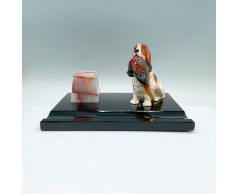 A rare featuring glossy black base a pink and gray stone inkwell, and a figure of a dog with brown spots and holding a red, b