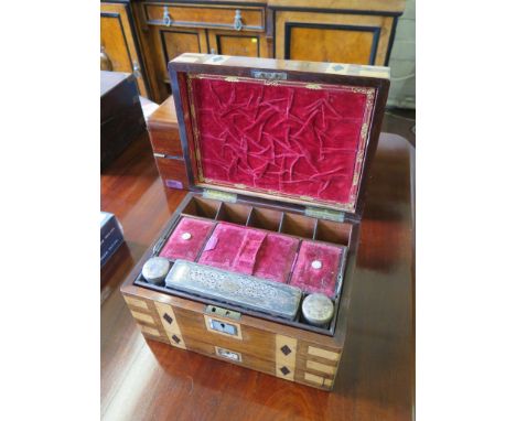 An early Victorian rosewood travelling compendium box, inlaid with satinwood and ebony to imitate brass bindings, the lid and