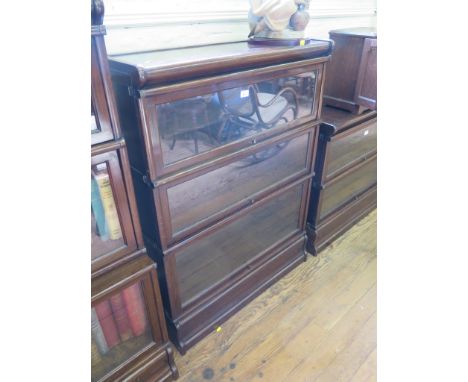 A Globe Wernicke oak graduated three tier bookcase, with glazed fall fronts, 86cm wide, 115cm high