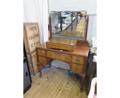 A walnut dressing table with bevelled shaped mirror over five drawers on cabriole legs and club feet, 101cm wide 