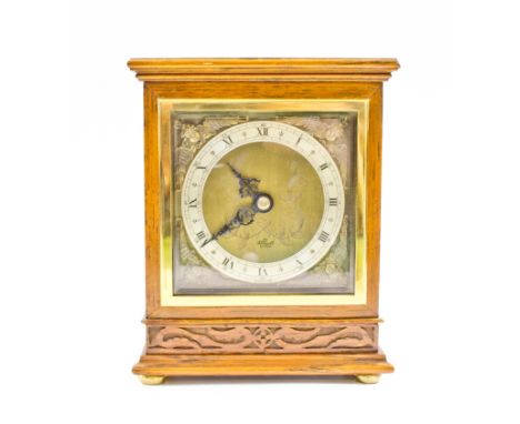 An early 20th century mahogany mantel clock, the shaped top carved with flowerhead and foliage over a silvered dial (rubbed) 
