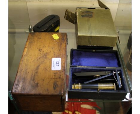 A blacked metal and brass monocular portable microscope by R&J Beck Limited, a box of slides, a pair of opera glasses and a S